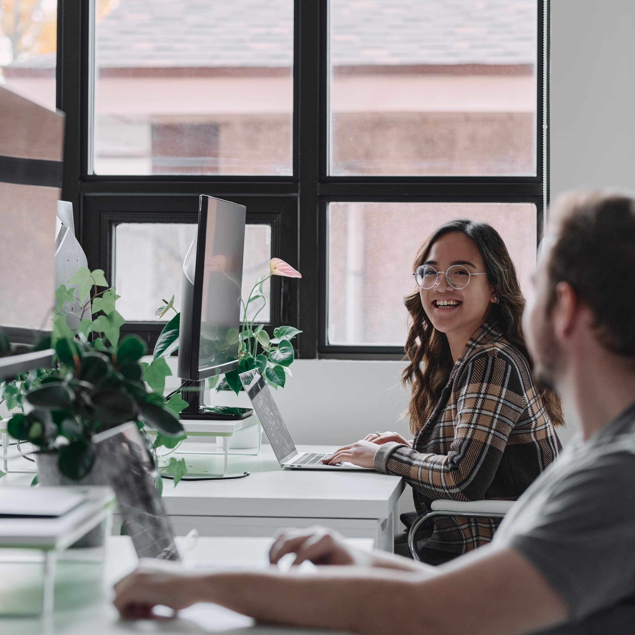 two young professionals collaborating at desktop computers