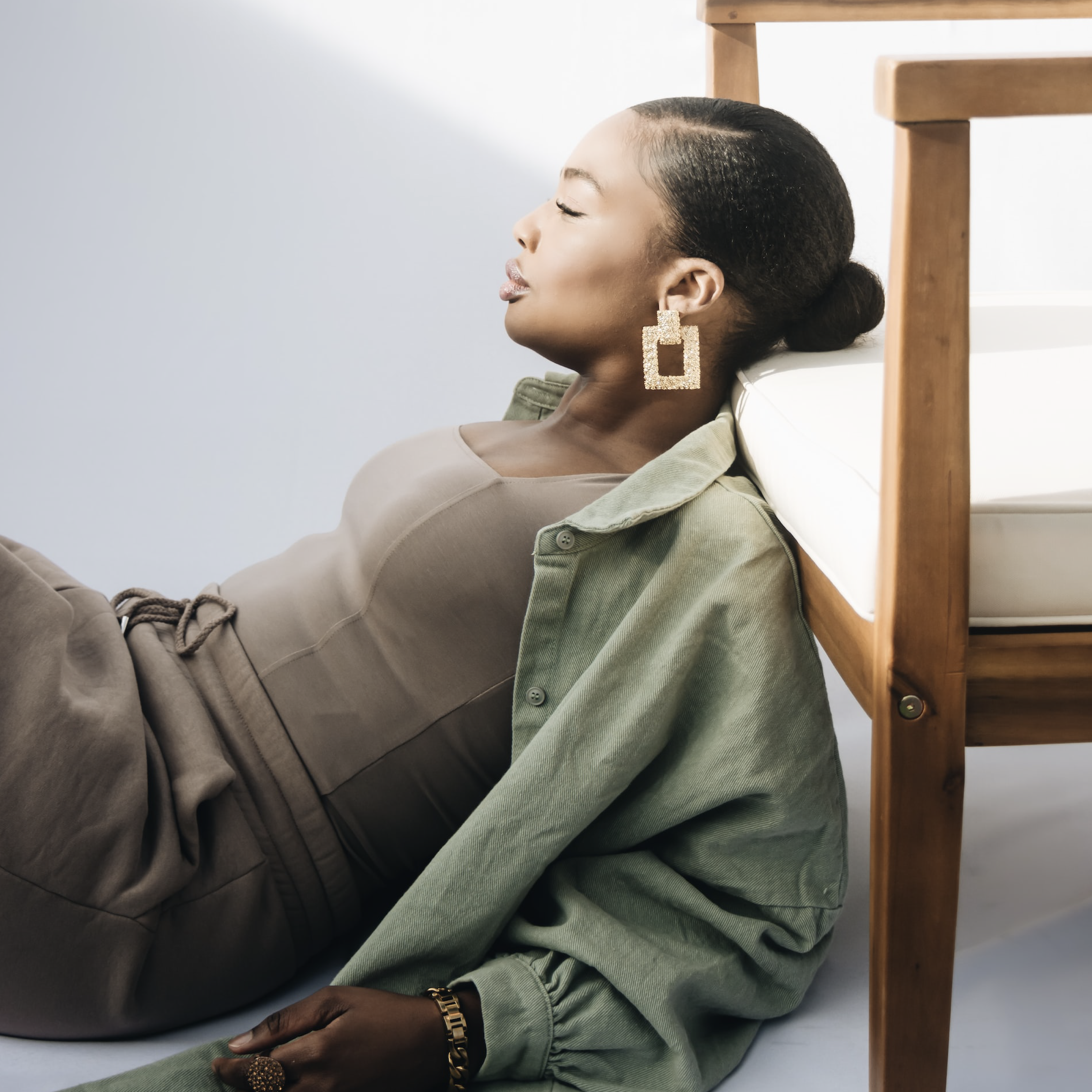 Woman on sitting on the floor with her head resting on a chair.